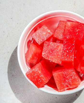 A bowl of watermelon cubes on a table
